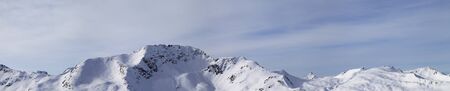 Panorama of high winter mountains with snowy slopes and sunlight cloudy sky at morning. Italian Alps. Livigno, region of Lombardy, Italy, Europe.の写真素材