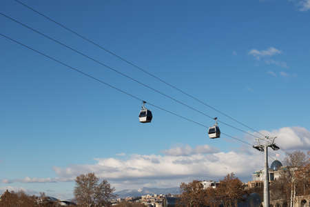 Cableway from Park Rike to ancient fortress Narikala in center Tbilisi, capital of Georgia. City, mountains and blue sky with clouds at background.のeditorial素材