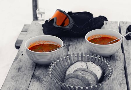 Black and white wooden table with lunch in outdoor cafe at Georgia ski resort. Winter vacation. Selective color effect.の写真素材