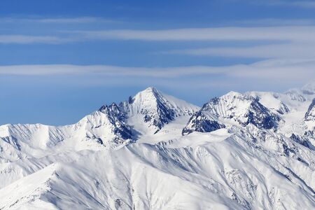 High snowy mountains and blue sky with clouds at cold winter day. Caucasus Mountains, Georgia region Gudauri.の写真素材