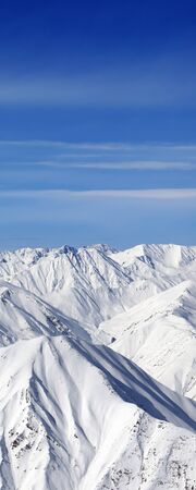High snowy mountains and blue sky with clouds at sunny winter day. Caucasus Mountains, Georgia region Gudauri.の写真素材