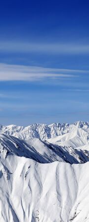 High snowy mountains and blue sky with clouds at sunny winter day. Caucasus Mountains, Georgia region Gudauri.の写真素材