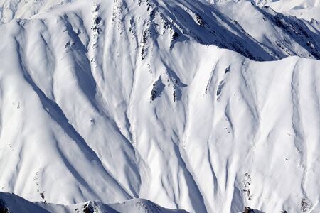 High mountains with sunlit snowy slope at cold winter day. Caucasus Mountains, Georgia region Gudauri.の写真素材