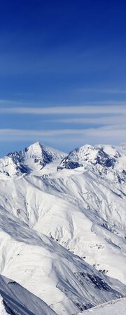 High snowy mountains and blue sky with clouds at sunny winter day. Caucasus Mountains, Georgia region Gudauri.の写真素材
