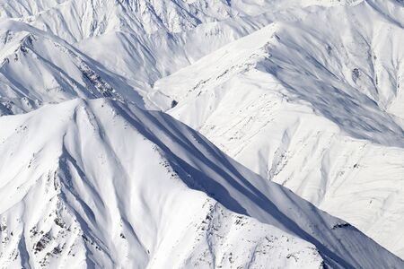 High mountains with sunlit snowy slope at cold winter day. Caucasus Mountains, Georgia region Gudauri.の写真素材