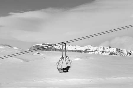 Snowy slope with new-fallen snow, ski-lift and sky with clouds at sun winter day. Caucasus Mountains, Shahdagh, Azerbaijan. Black and white toned landscape.のeditorial素材