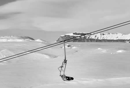 Snowy slope, chair-lift and cloudy sky at cold winter day. Caucasus Mountains, Shahdagh, Azerbaijan. Black and white toned landscape.のeditorial素材