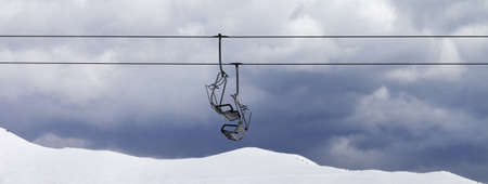 Chair lifts and snowy off-piste slope at gray day. Caucasus Mountains, Georgia, region Gudauri at winter. Panoramic view.の写真素材