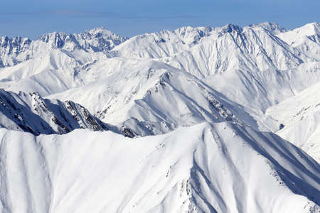 High snowy mountains and blue sky with clouds at cold winter day. Caucasus Mountains, Georgia region Gudauri.の写真素材