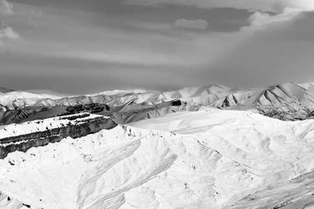 Snowy winter mountains and sky with beautiful clouds at nice sun evening. Caucasus Mountains, Shahdagh, Azerbaijan. Black and white toned landscape.の写真素材