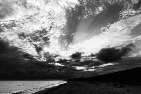 Sea beach in evening and sunlight clouds. Wide angle view. Black and white toned landscape.の写真素材