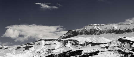 Panorama of high snowy mountains and sky with clouds at sunny winter day. Caucasus Mountains, Shahdagh, Azerbaijan. Black and white toned landscape.の写真素材