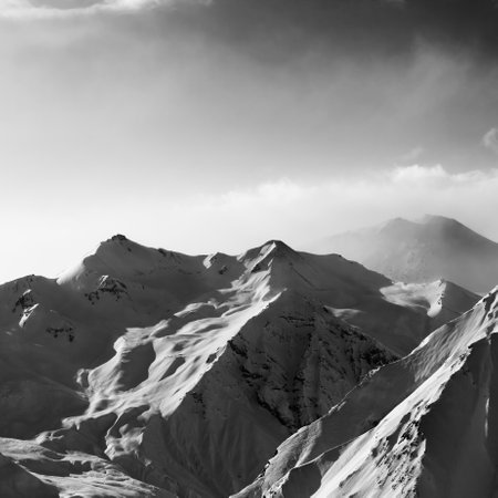 Black and white view on snowy sunlight mountains in early morning. Winter Caucasus Mountains in fog, Georgia, region Gudauri.の写真素材