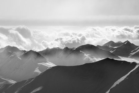 Silhouette of evening sunlight snowy mountains in mist. Caucasus Mountains, Georgia, region Gudauri...