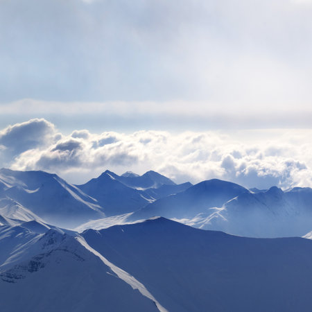 Silhouette of evening sunlight snowy mountains in mist. Caucasus Mountains at winter, Georgia, region Gudauri.の写真素材
