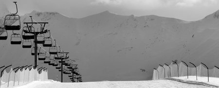 Black and white view on snow skiing piste and ropeway. Caucasus Mountains. Georgia, region Gudauri in evening.の写真素材