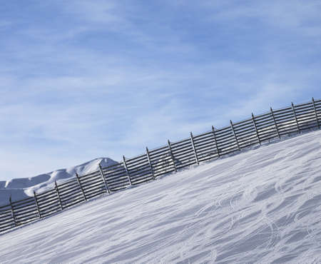 Snowy ski track prepared by snowcat with trace from skis and snowboards. High mountains at sunny winter day. Italian Alps. Livigno, region of Lombardy, Italy Europe.の写真素材