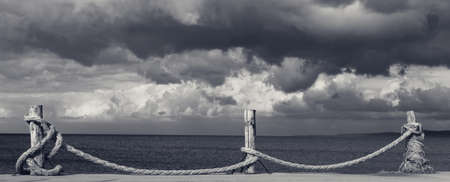 Panoramic view on black and white seafront, sea and cloudy storm sky. Turkey, Erdek, coast of Marmara.の写真素材