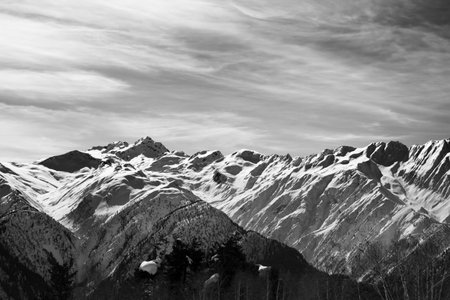 Sunlight high snowy mountains in wind winter day. Caucasus Mountains. Svaneti region of Georgia. Black and white toned landscape. High contrast.の写真素材