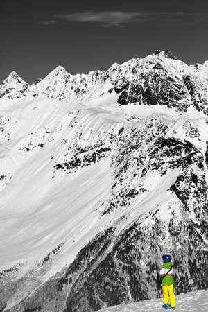 Young skier on top of snow mountains at nice sun day. Caucasus Mountains in winter, Svaneti region of Georgia. Black and white toned landscape. Selective color effect.の写真素材