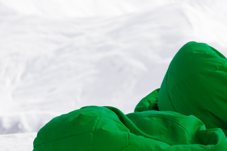 Green bean bag chairs in outdoor cafe at ski resort and snow slope for freeriding at background. Mountains in winter sun day.の写真素材