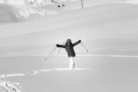 Happy girl on off-piste slope with new fallen snow at nice winter day. Caucasus Mountains, Georgia, region Gudauri. Black and white toned image.の写真素材