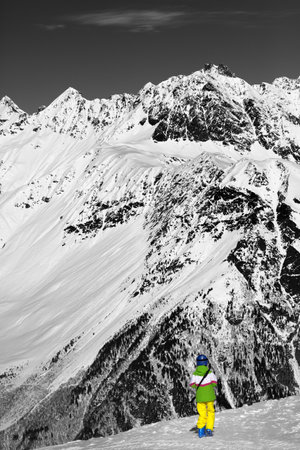 Young skier on top of snow mountains at nice sun day. Caucasus Mountains in winter, Svaneti region of Georgia. Black and white toned image. Selective color effect.の写真素材