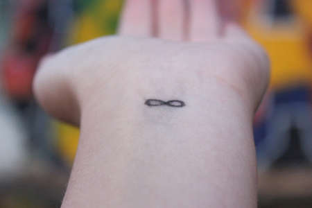 closeup of the arm with an infinity symbol tattooed in his wrist. infinity sign on the hand. endless love conceptの写真素材