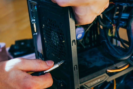 Senior male tech works in hardware repair facility.guy is assembling a computer.の写真素材