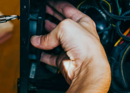 Senior male tech works in hardware repair facility.guy is assembling a computer.の写真素材