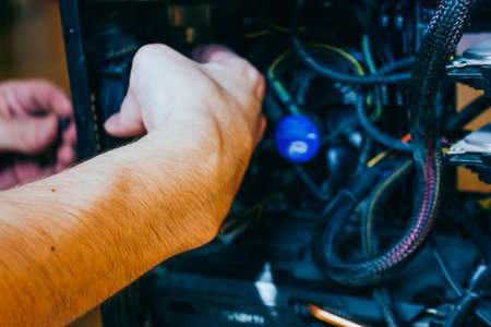 Senior male tech works in hardware repair facility.guy is assembling a computer.の写真素材