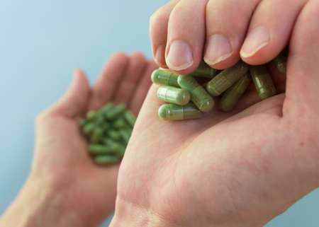 Chlorella in capsules super food. vegetable dietary Supplement Chlorella.capsules in hands top view.