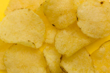 some potato chips on a yellow background.の写真素材