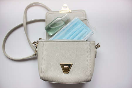 Top view or flat lay of woman's bag accessories with hygienic mask and sanitizer gel , Protection from COVID-19 or Coronavirus concept.の写真素材