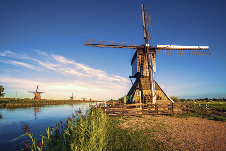 Sunrise light shining and reflecting on the right wing of the Kinderdijk windmill, the UNESCO world...