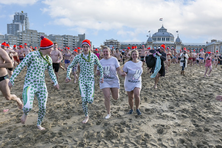 SCHEVENINGEN, 1 January 2018 - two disguised Dutch couples running on the beach for their first new year dip in the frozen North Sea water, The Netherlandsのeditorial素材