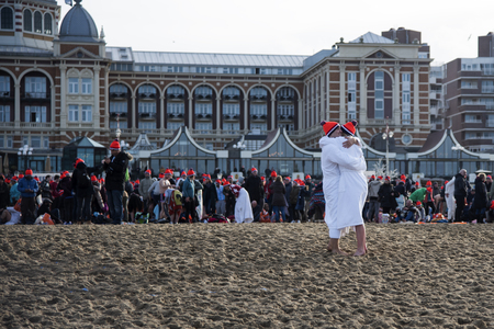 SCHEVENINGEN, 1 January 2018 - Couple congrats each other for having accomplished the new year dive in a frozen North Sea waterのeditorial素材