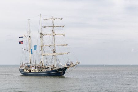Antique tall ship, vessel entering the harbor of The Hague, Scheveningen under a sunny and blue skyの写真素材