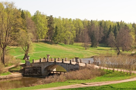 The stone bridge across the river in the park in springの写真素材