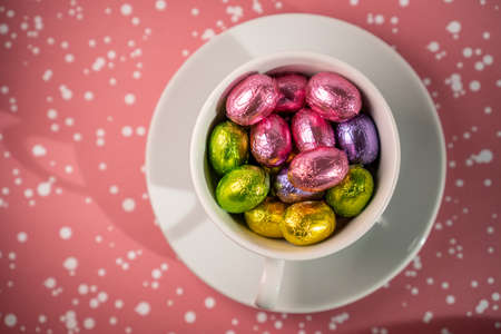 cup with chocolates against red backgroundの写真素材