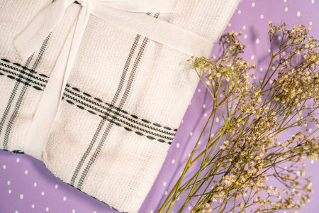 new kitchen towels and dried flowers on purple background