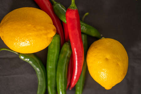 red and green chili peppers and yellow lemonの写真素材
