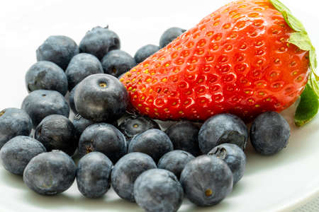 blueberries and strawberries in a white bowl