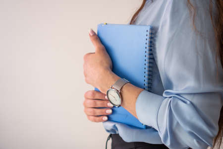 office girl in blue shirt and pearl necklace with blue notebookの写真素材