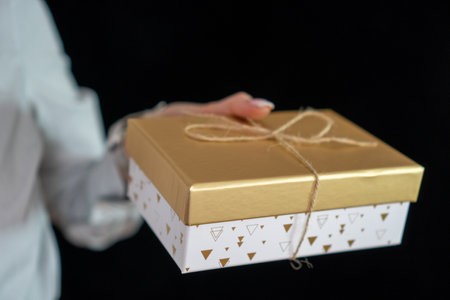 girl with manicure holding a gold gift