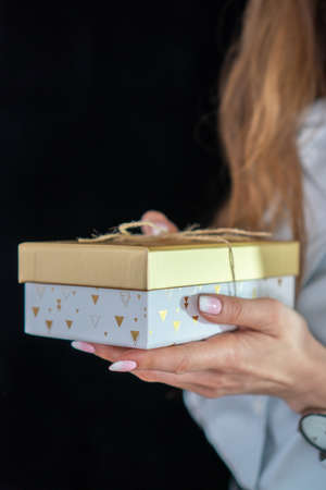 girl with manicure holding a gold giftの写真素材