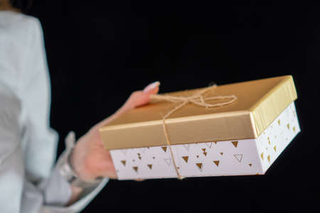 girl with manicure holding a gold gift