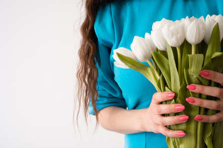 girl in a blue and long hair dress with white tulipsの写真素材