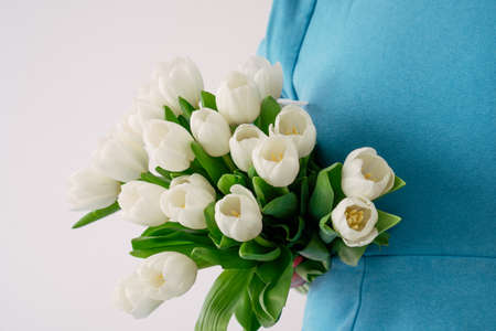 girl in a blue and long hair dress with white tulipsの写真素材