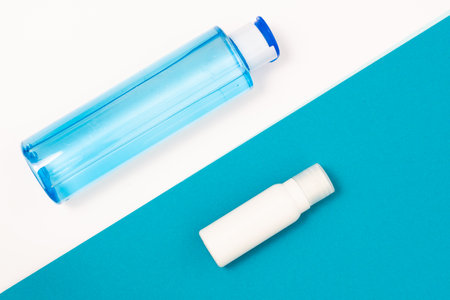 face tonic and shower gel on interesting background folded of colored paper leaves of different colorsの写真素材